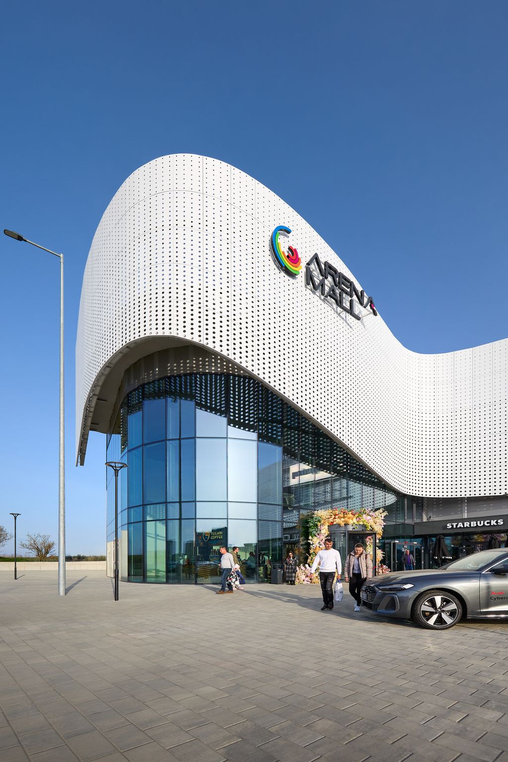 Curved volume with the Arena Mall logo and glazed entrance, Arena Mall Bacău