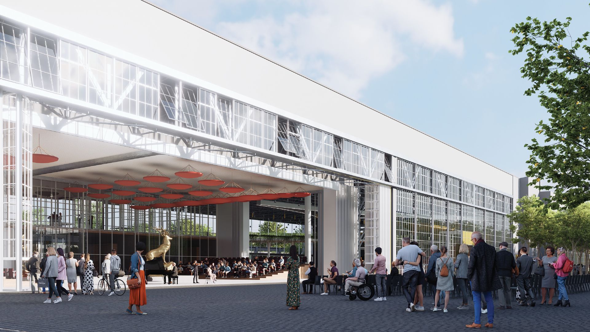 Performance hall inside a hangar: exposed white trusses, red suspended acoustic discs and tiered audience seating.