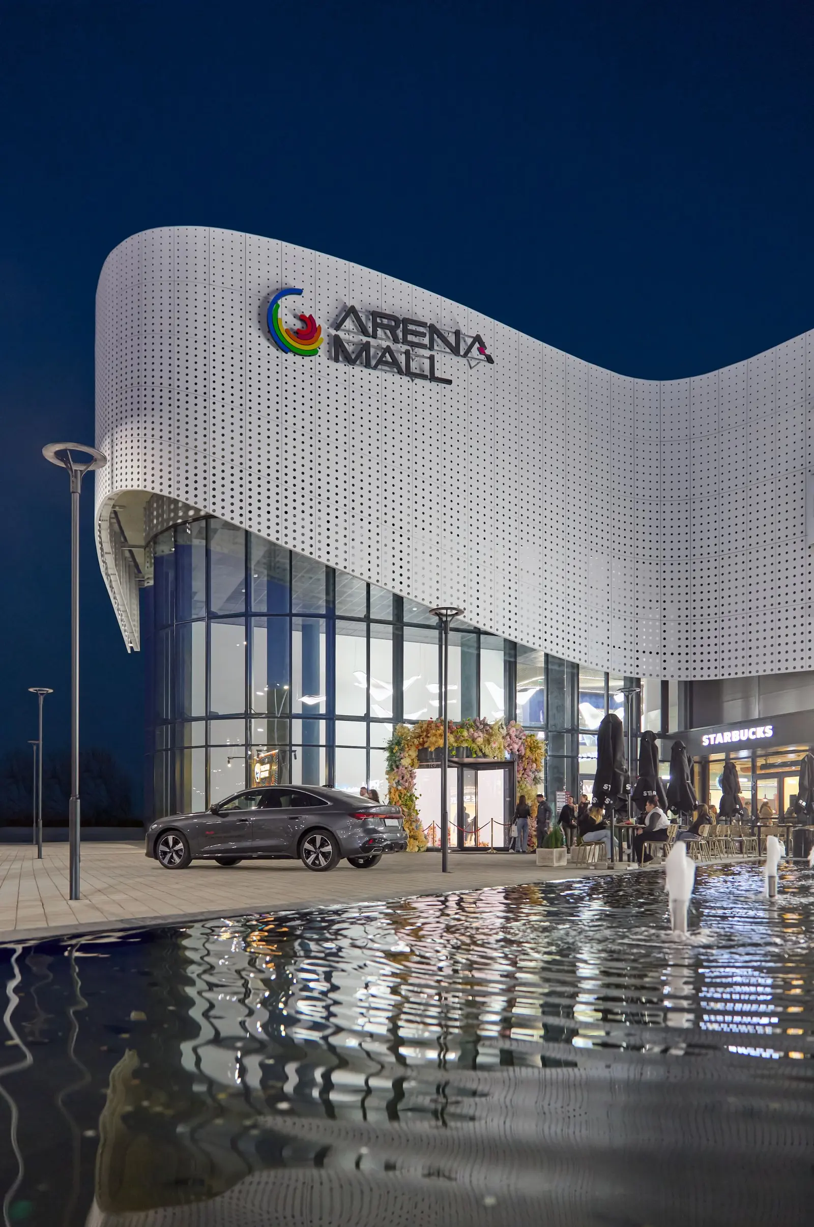 Intrarea vitrată a Arena Mall Bacău, cu sigla Arena Mall