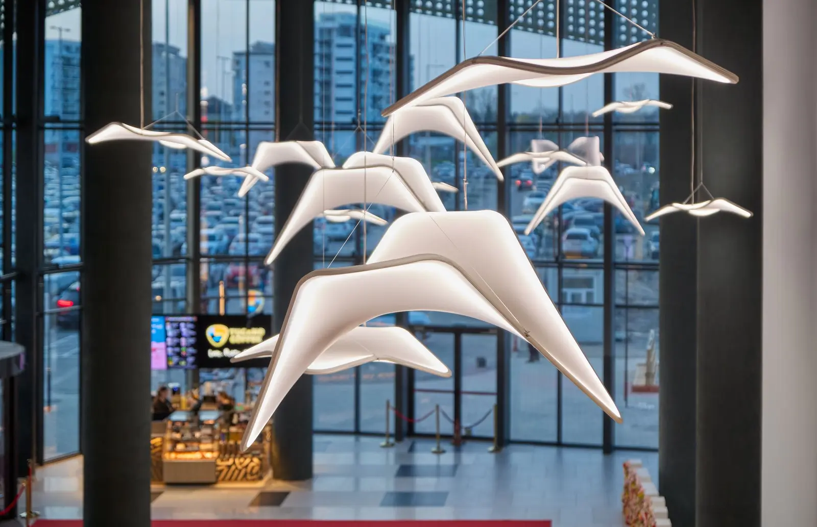 Decorative installation of suspended white birds beside the glazed façade, Arena Mall Bacău