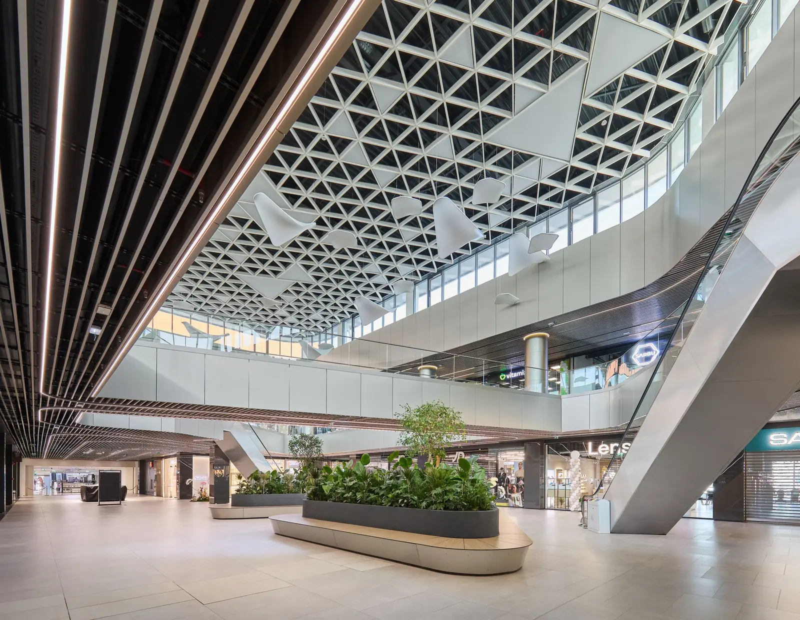 Interior atrium with wooden slatted ceiling, escalators and green planters, Arena Mall Bacău