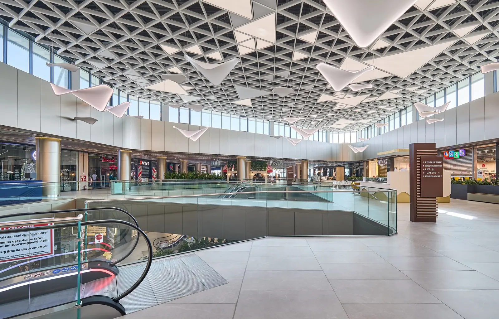 Mall interior with escalators and white triangular ceiling, Arena Mall Bacău