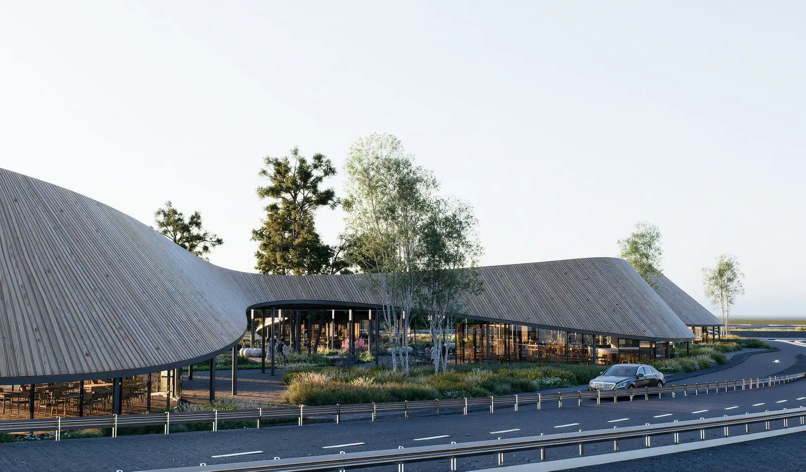 The space beneath the canopy, with tables, the water channel and tall pines passing through the roof